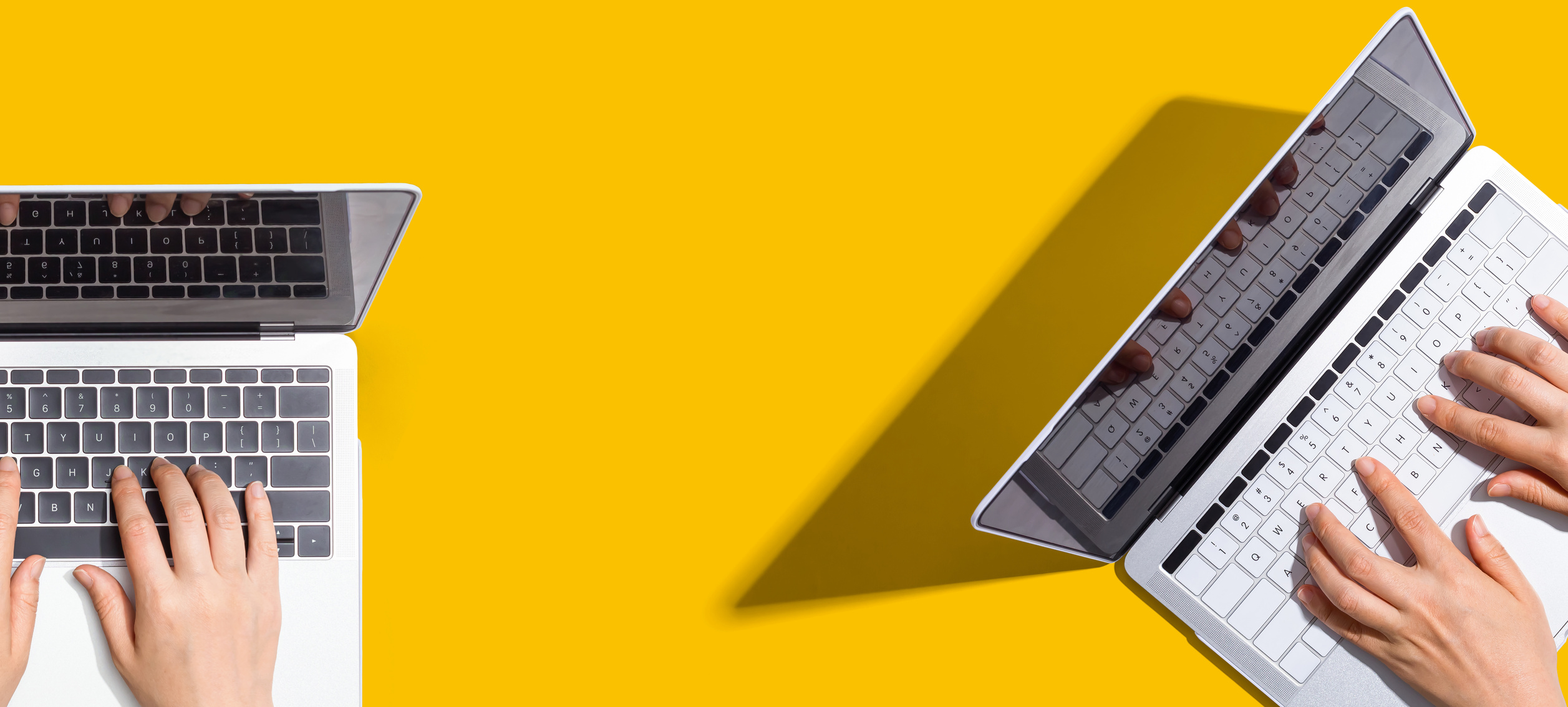 Two people working together with laptops